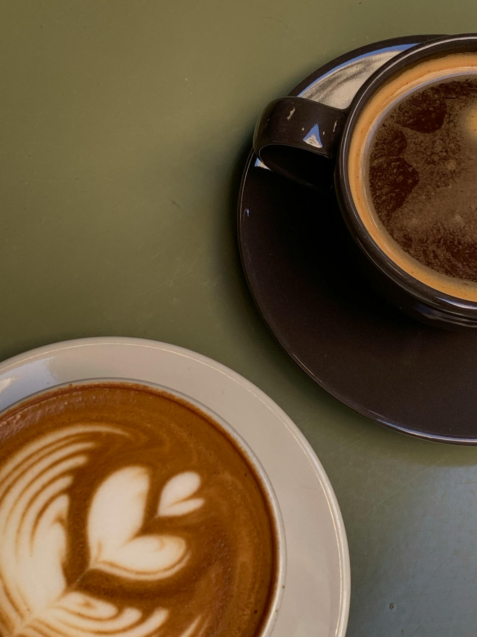 Dvě šálky kávy s latte art na stole