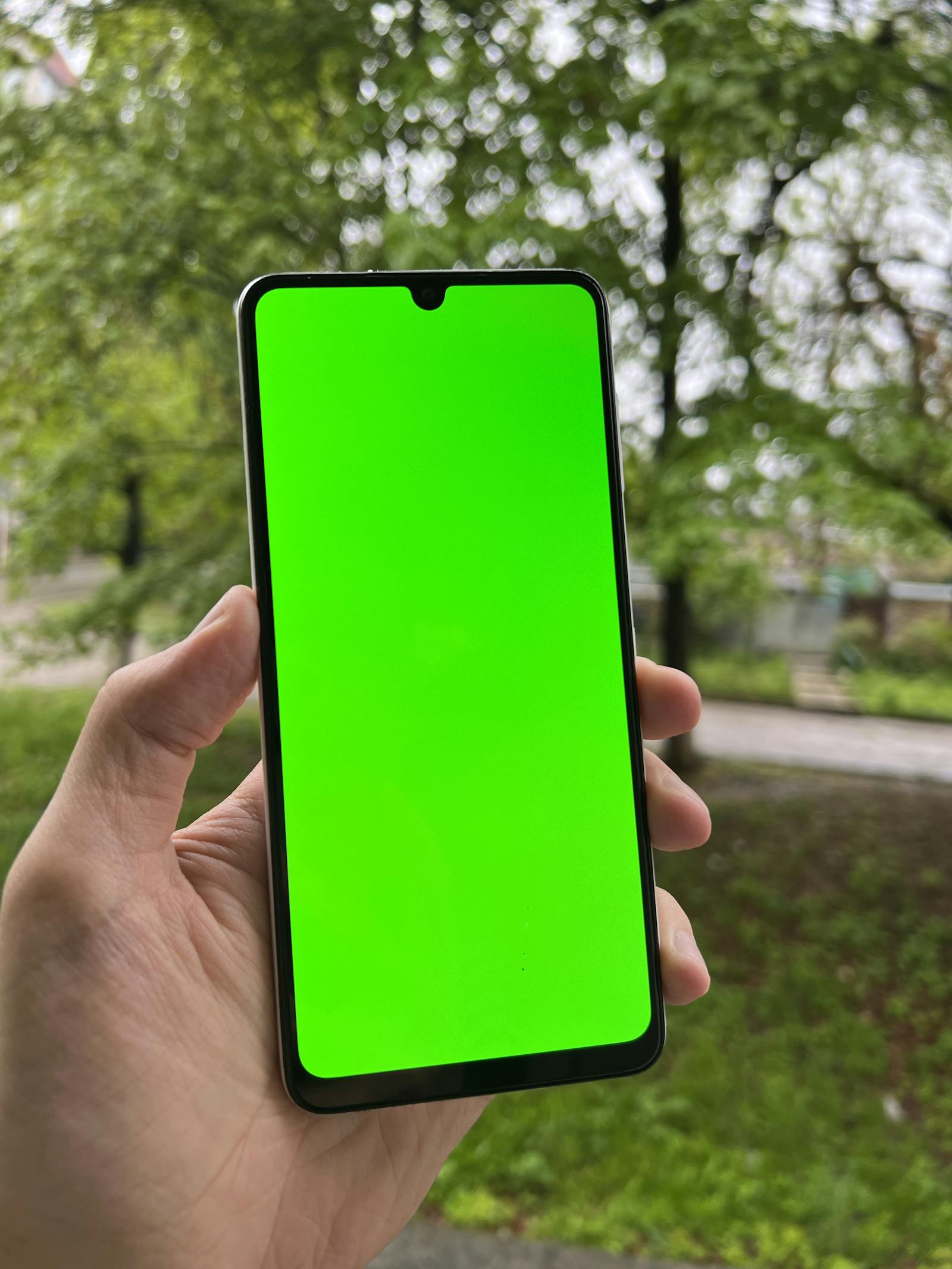 Detail ruky držící chytrý telefon venku